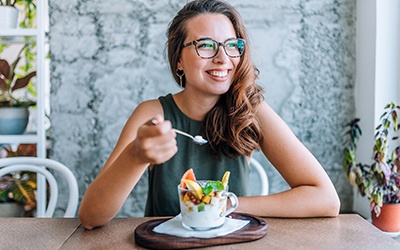 Woman smiling while eating healthy breakfast