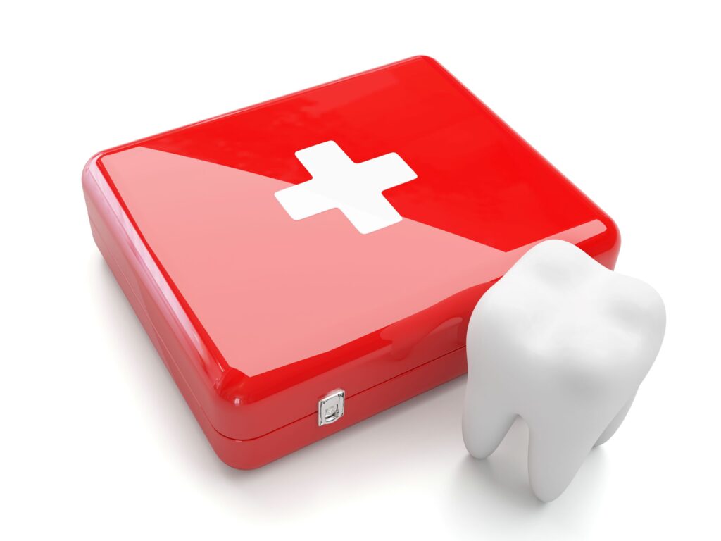 Large model tooth next to red first aid kit with white background